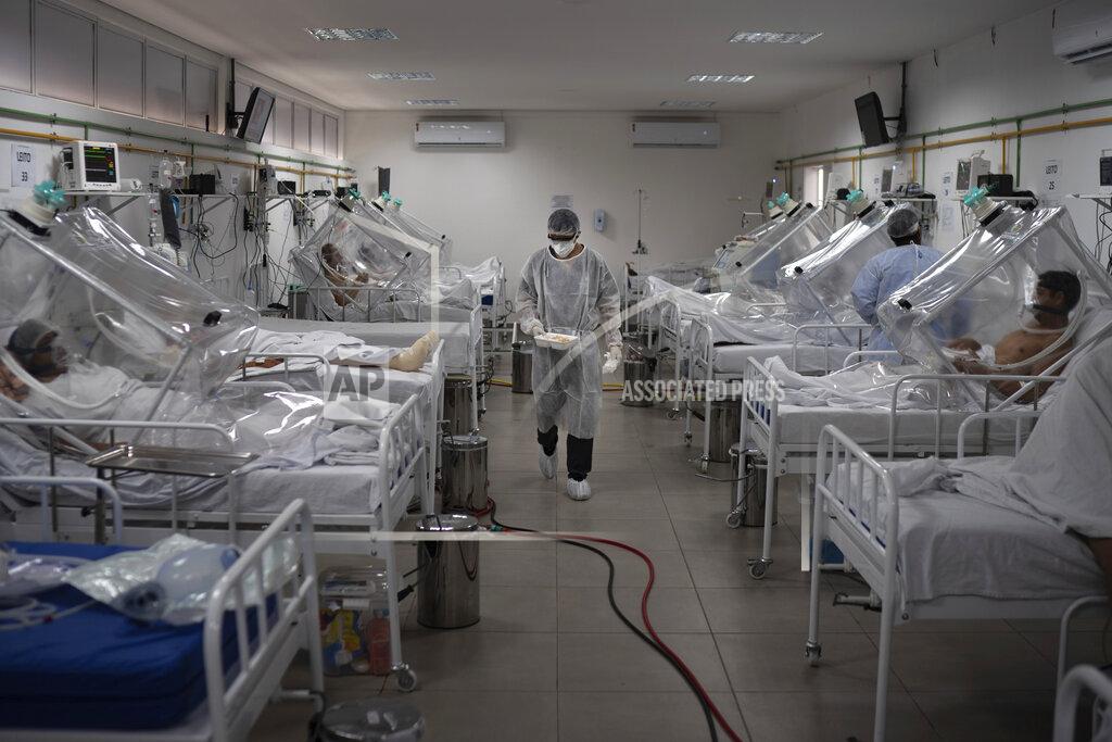 Felipe Dana COVID-19 patients are treated inside a non-invasive ventilation system named the 'Vanessa Capsule' at the municipal field hospital Gilberto Novaes in Manaus, Brazil, Monday, May 18, 2020. The field hospital set up inside a school currently has nearly 150 beds and is operating near its limit as it treats patients both from the capital and from rural areas of the Amazon state. (AP Photo/Felipe Dana)