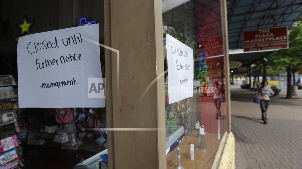 Eric Gay FILE - In this March 24, 2020, file photo, a pedestrian passes a business which has closed temporarily in San Antonio. The coronavirus crisis is upending service businesses, and the crisis may permanently change the way Americans work, shop and socialize, even after the disease fades away. (AP Photo/Eric Gay, File)