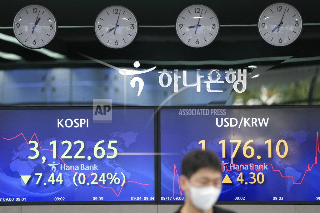 Lee Jin-Man A currency trader walks by the screens showing the Korea Composite Stock Price Index (KOSPI), left, and the foreign exchange rate between U.S. dollar and South Korean won at a foreign exchange dealing room in Seoul, South Korea, Friday, Sept. 17, 2021. Asian shares were mixed on Friday after a hodge-podge of economic data led Wall Street to close mostly lower. (AP Photo/Lee Jin-man)