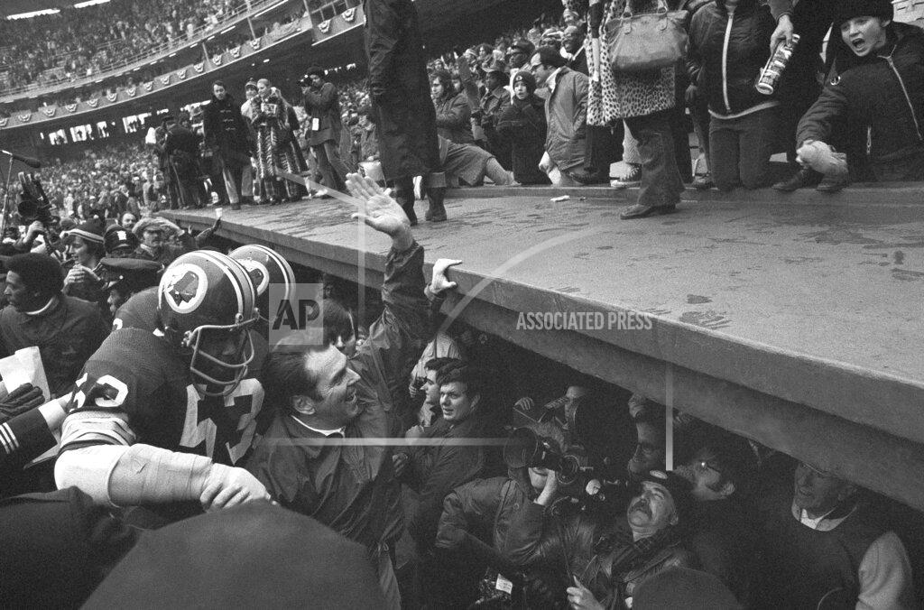 Anonymous FILE- In this Dec. 24, 1972, file photo, Washington Redskins coach George Allen waves to fans at Robert F. Kennedy Stadium in Washington as he leaves the field following the team's 16-3 win over the Green Bay Packesr in an NFL playoff game. At left is linebacker Harold McLinton. Washington’s NFL team will get rid of the name "Redskins" on Monday, July 13, according to multiple reports. It’s unclear when a new name will be revealed for one of the league’s oldest franchises. The team launched a "thorough review" of the name July 3.(AP Photo, File)