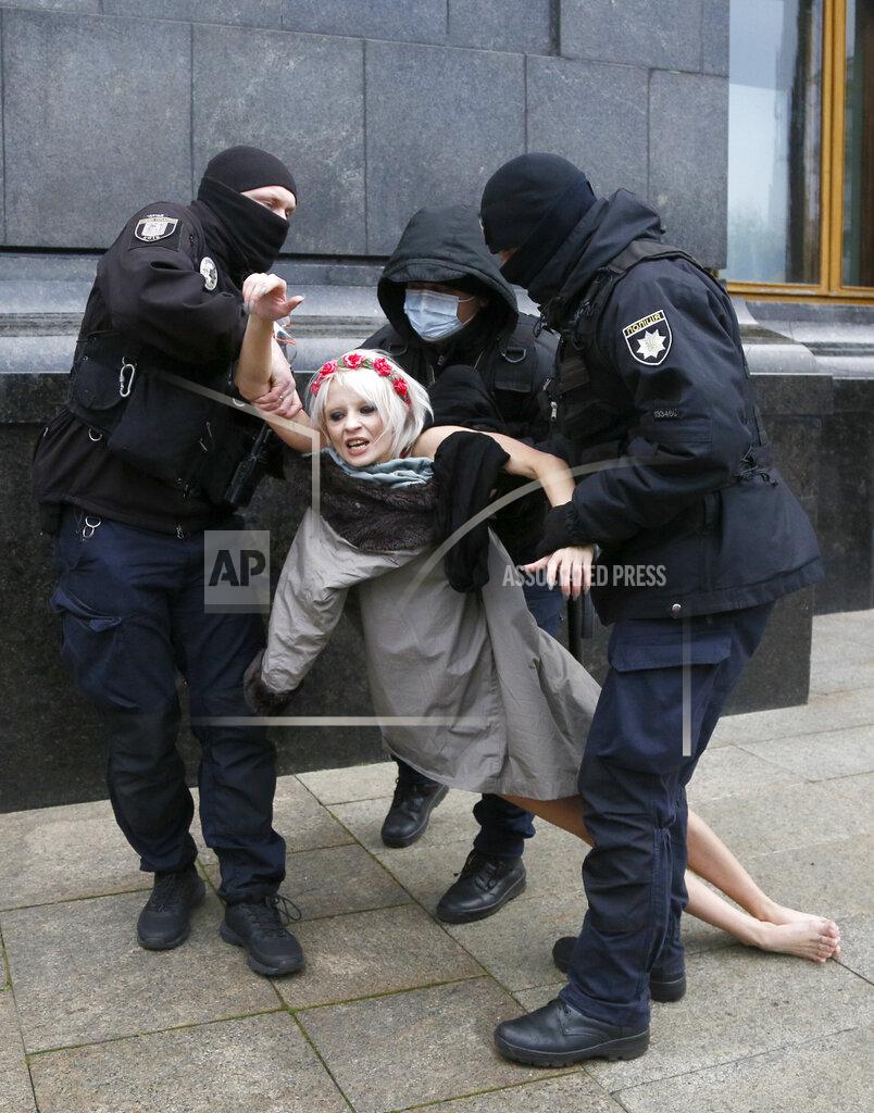 Efrem Lukatsky Police detain an activist from Ukrainian female rights organization "Femen" on the International Day for the Elimination of Violence against Women as she protested naked in front of the Presidential Office in Kyiv, Ukraine, Wednesday, Nov. 25, 2020. Writing on her chest reads "Istanbul". Femen is demanding the Ukrainian authorities to ratify the Istanbul Convention on the protection of women. (AP Photo/Efrem Lukatsky)
