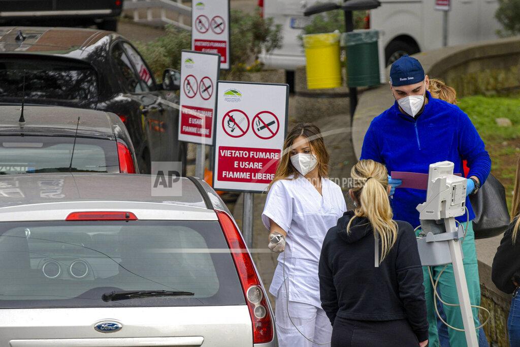Alessandro Pone FILE - In this Nov. 13, 2020 file photo, hospital personnel Medical give assistance to passengers sitting inside a car outside the Cardarelli hospital in Naples, southern Italy, Friday, Nov. 13, 2020. The coronavirus pandemic has heightened the urgency of the plight of those seeking medical care in public hospitals in Italy’s economically underdeveloped south.(Alessandro Pone/LaPresse via AP)