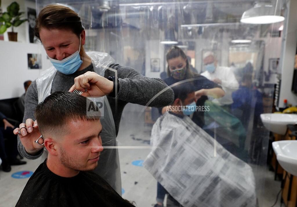Frank Augstein People get their hair cut at a busy hairdressers in London, Monday, April 12, 2021. Millions of people in England will get their first chance in months for haircuts, casual shopping and restaurant meals on Monday, as the government takes the next step on its lockdown-lifting road map.(AP Photo/Frank Augstein)