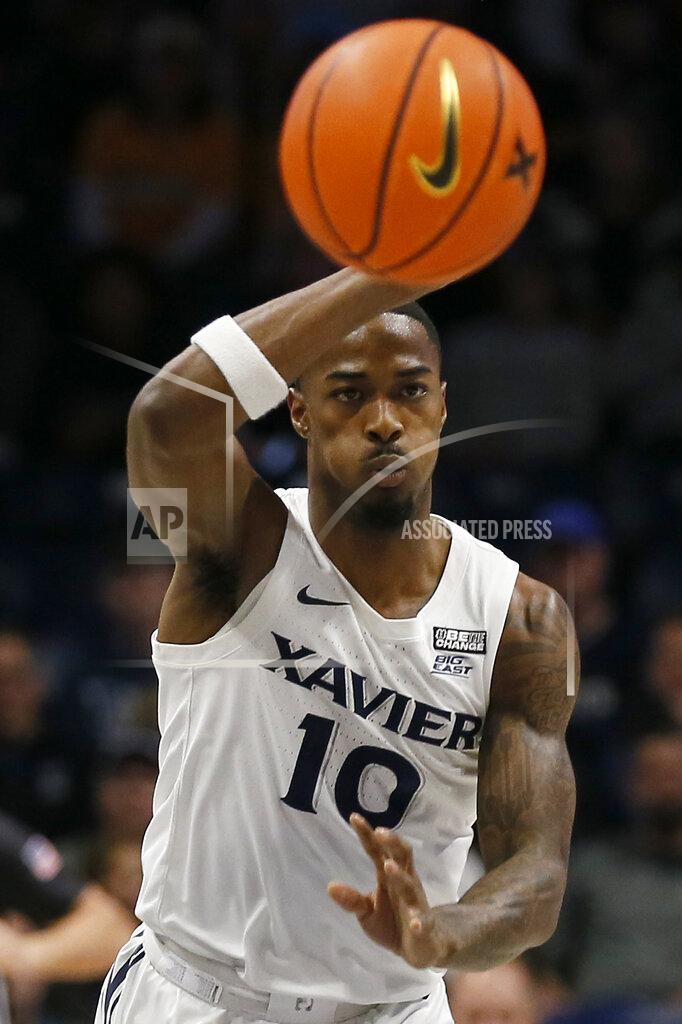 Sam Greene Xavier guard Nate Johnson (10) passes to the baseline in the first half of an NCAA college basketball game against Marquette in Cincinnati, Saturday, Dec. 18, 2021. (Sam Greene/The Cincinnati Enquirer via AP)