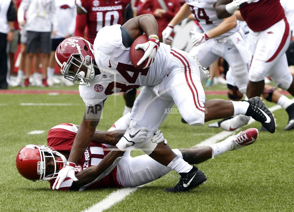 Michael Woods Alabama running back Damien Harris is tripped up by Arkansas Ryan Pulley in the first half of an NCAA college football game Saturday, Oct. 6, 2018, in Fayetteville, Ark. (AP Photo/Michael Woods)