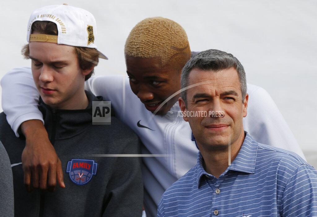 Steve Helber Virginia head coach, Tony Bennett, right, looks to the crowd along with Mamadi Dikite, center, and Austin Katstra, left, as the team is welcomed by fans as they return home after their win of the championship in the Final Four NCAA college basketball tournament against Texas Tech, in Charlottesville, Va., Tuesday, April 9, 2019. (AP Photo/Steve Helber)