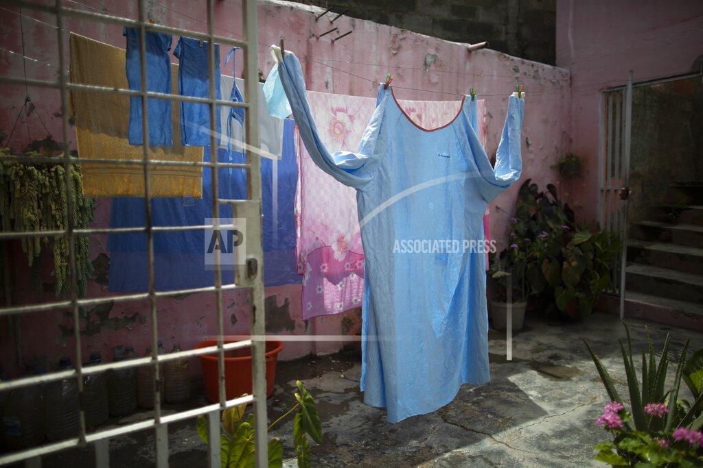 Ariana Cubillos One of Elena's Suazo's two medical gowns hangs to dry at her parents' home in the Catia neighborhood of Caracas, Venezuela, Tuesday, Sept. 29, 2020, in between her twice-daily trips to care for her hospitalized father in the COVID-19 wing of the public, Jose Gregorio Hernandez hospital. On a cafeteria worker's monthly salary of less than $ , Suazo had no money to buy the needed protective gear, so her younger brother bought her one suit and her son’s mother-in-law gave her a second, allowing her to attend him inside the hospital twice a day. (AP Photo/Ariana Cubillos)