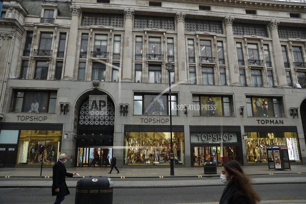 Matt Dunham People wearing face masks to try to curb the spread of coronavirus walk past the Topshop flagship store on Oxford Street, in London, Monday, Nov. 30, 2020. Arcadia Group, the retail empire of tycoon Philip Green, which owns well-known British fashion chains like Topshop and employs around 15,000 people, appears to be on the brink of collapse following the economic shock of the coronavirus pandemic. (AP Photo/Matt Dunham)