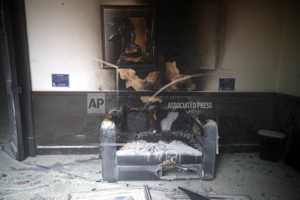 Moises Castillo A couch and art work destroyed by fire are seen inside the Congress building after protesters set a part of building on fire, in Guatemala City, Saturday, Nov. 21, 2020. Hundreds of protesters were protesting in various parts of the country Saturday against Guatemalan President Alejandro Giammattei and members of Congress for the approval of the 2021 budget that reduced funds for education, health and the fight for human rights. (AP Photo/Moises Castillo)