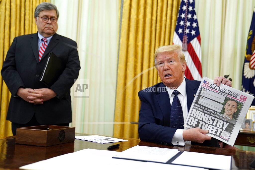 Evan Vucci President Donald Trump holds up a copy of the New York Post as speaks before signing an executive order aimed at curbing protections for social media giants, in the Oval Office of the White House, Thursday, May 28, 2020, in Washington, as Attorney General William Barr watches. (AP Photo/Evan Vucci)