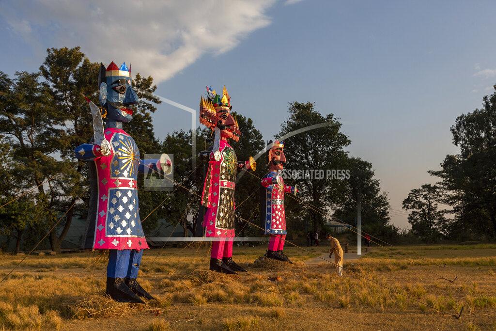 Ashwini Bhatia A priest gets ready to conduct prayers next to the effigies of mythological demon king Ravana and his kins during Dussehra festival celebrations toned down due to the coronavirus pandemic in Dharmsala, India, Sunday, Oct. 25, 2020. The Hindu festival season is traditionally laced with an unmatched fanfare and extravaganza, with socializing being the hallmark of the celebration. But this year's festivities have started on a pale note. (AP Photo/Ashwini Bhatia)