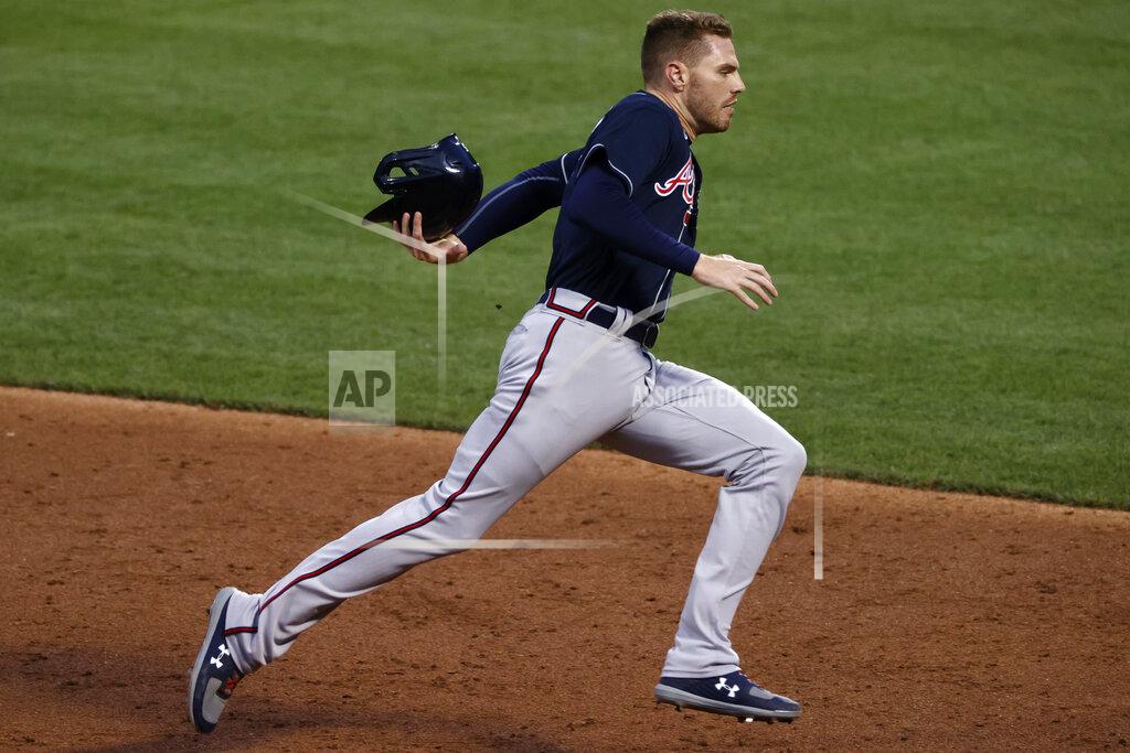 Adam Hunger Atlanta Braves' Freddie Freeman attempts to catch his helmet that had fallen off as he was running the bases against the New York Mets during the third inning of a baseball game Sunday, July 26, 2020, in New York. (AP Photo/Adam Hunger)