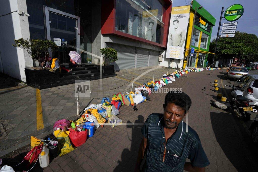 Eranga Jayawardena A man waits to buy kerosene oil standing by a line of empty canisters placed outside a fuel station amid shortage of cooking gas in Colombo, Sri Lanka, Thursday, June 23, 2022. Sri Lankans have endured months of shortages of food, fuel and other necessities due to the country’s dwindling foreign exchange reserves and mounting debt, worsened by the pandemic and other longer term troubles. (AP Photo/Eranga Jayawardena)