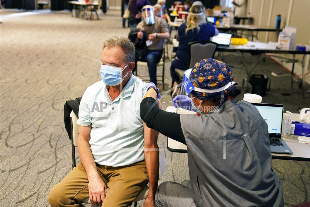 Jim Mone Ron Tupy receives a vaccination, Thursday, Jan. 21, 2021 at the Earle Brown Heritage Center in Brooklyn Center, Minn. Minnesota on Thursday opened up nine locations for coronavirus vaccinations as part of a pilot program reserved for people 65 and over. Demand for the program was exceptionally heavy, with slots for the few available doses quickly filling after registration opened two days earlier. (AP Photo/Jim Mone)