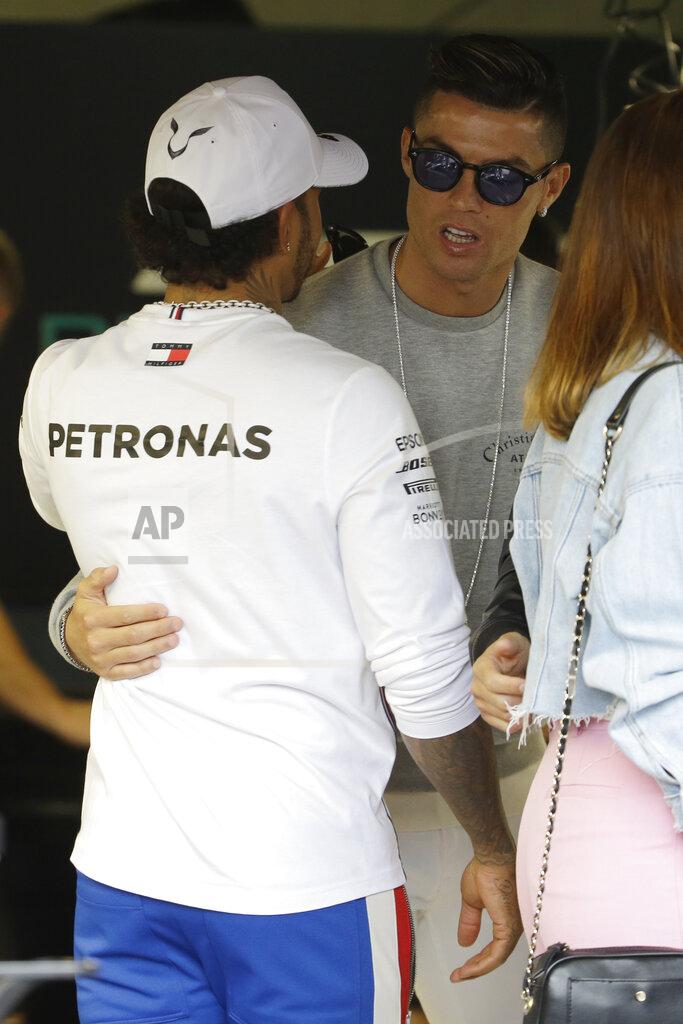 Luca Bruno Mercedes driver Lewis Hamilton of Britain, left, speaks with Cristiano Ronaldo at the pit line ahead of the second practice session at the Monaco racetrack, in Monaco, Thursday, May 23, 2019. The Formula one race will be held on Sunday. (AP Photo/Luca Bruno)