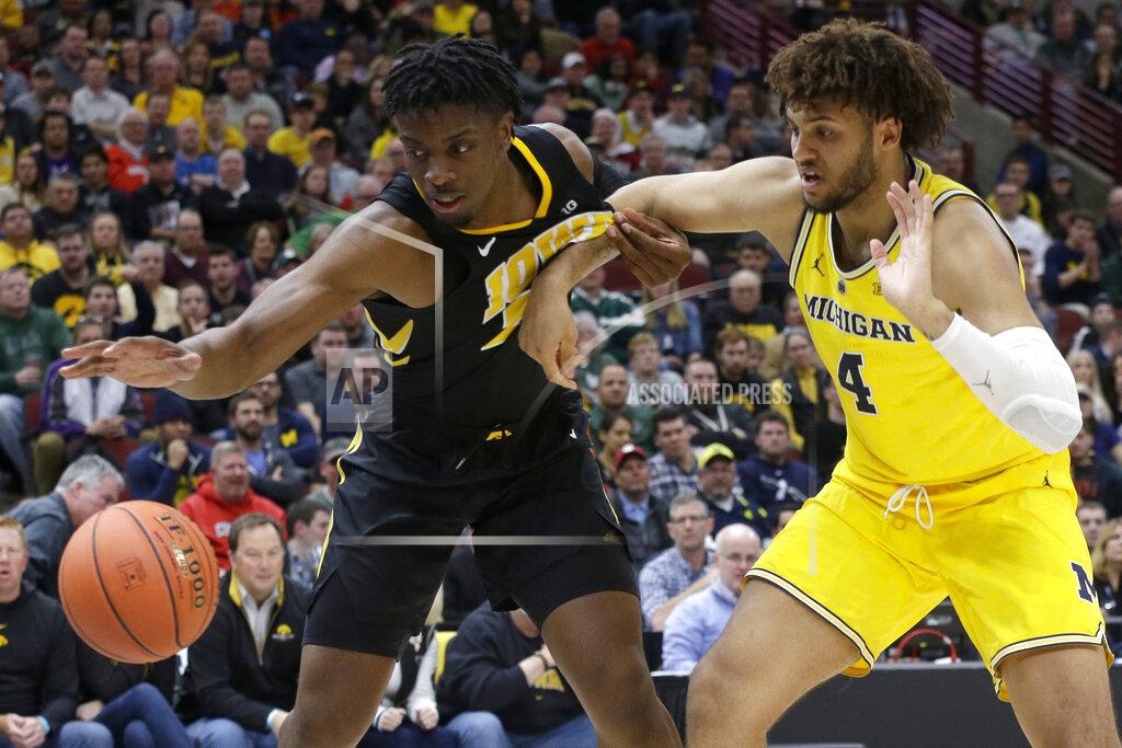 Kiichiro Sato Iowa's Tyler Cook (25) and Michigan's Isaiah Livers (4) battle for a loose ball during the second half of an NCAA college basketball game in the quarterfinals of the Big Ten Conference tournament, Friday, March 15, 2019, in Chicago. (AP Photo/Kiichiro Sato)