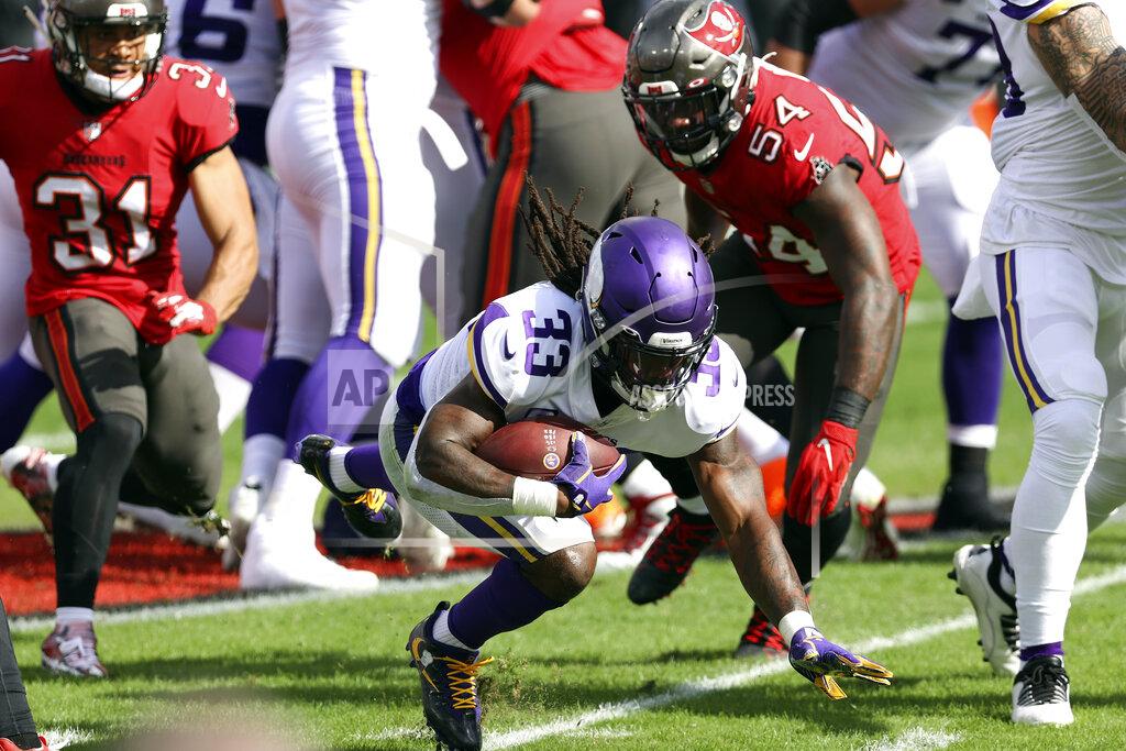 Mark Lomoglio Minnesota Vikings running back Dalvin Cook (33) dives for yardage after getting past Tampa Bay Buccaneers strong safety Antoine Winfield Jr. (31) and inside linebacker Lavonte David (54) during the first half of an NFL football game Sunday, Dec. 13, 2020, in Tampa, Fla. (AP Photo/Mark LoMoglio)