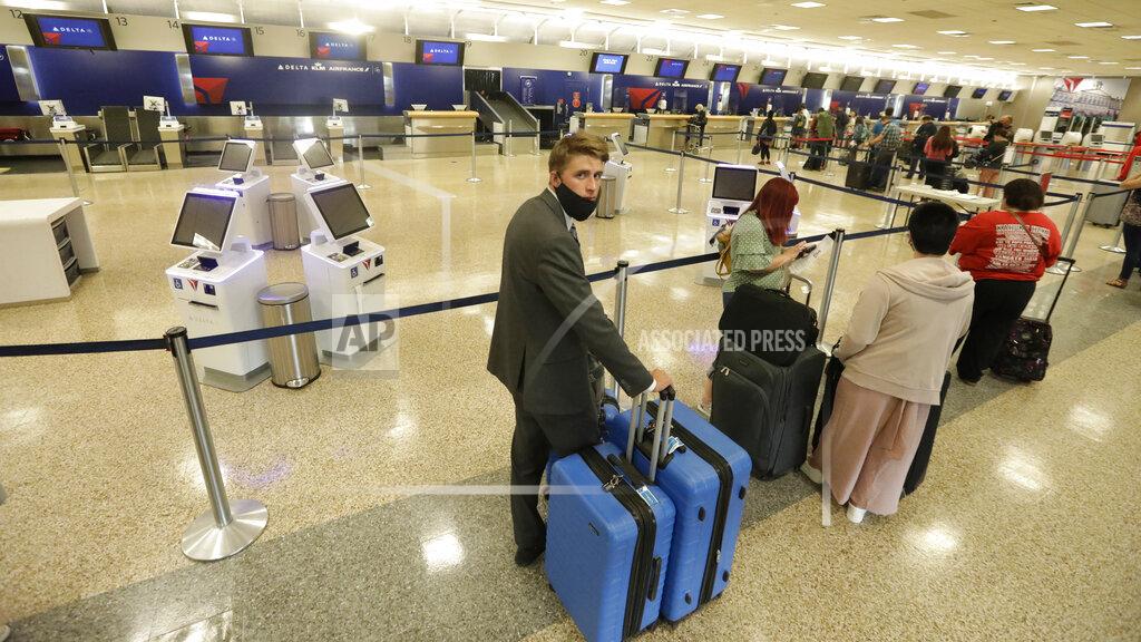 Rick Bowmer In this May 27, 2020, photo, Logan Morrison, 18, a missionary from The Church of Jesus Christ of Latter-day Saints, waits in line to get to ticket counter, at Salt Lake City International Airport, before leaving on his mission to St. Louis. After hastily bringing home 26,000 young men and women who were serving in foreign countries, the faith has begun sending many of them out again in their home countries with a new focus on online work that could stick even when the pandemic is over, church officials told The Associated Press. (AP Photo/Rick Bowmer)