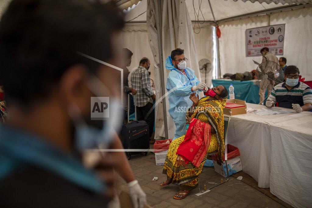 Altaf Qadri A health worker takes a nasal swab sample of a passenger to test for COVID-19 at a bus terminal in New Delhi, India, Wednesday, March 24, 2021. (AP Photo/Altaf Qadri)