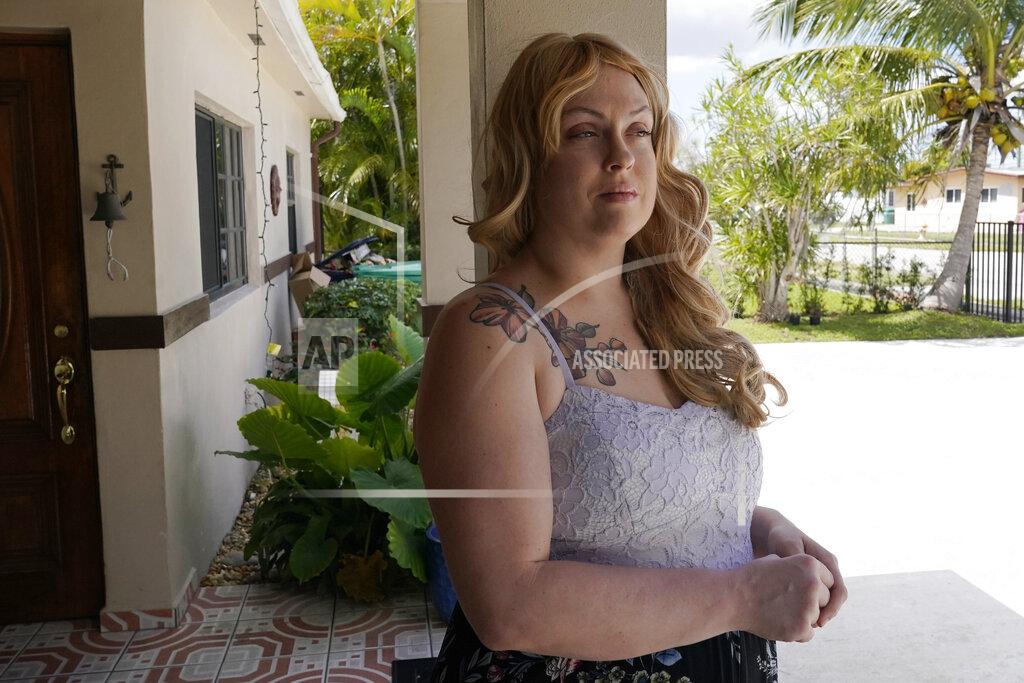 Marta Lavandier Nicole Russell looks out from her porch, Friday, March 12, 2021, in Kendall, Fla. Because of the pandemic, Nicole because fearful of leaving her home and retreated to her bedroom for days at a time. While some felt restricted by the confinement of home "caves", others found a sense of safety and comfort, becoming increasingly accustomed to the isolation. (AP Photo/Marta Lavandier)