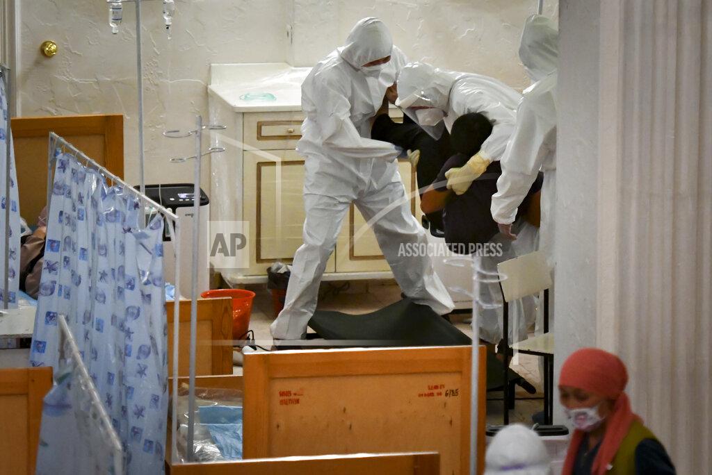 Vladimir Voronin Medical workers carry a patient who is suspected of having the coronavirus inside a restaurant that has been converted into a clinic in Bishkek, Kyrgyzstan, Wednesday, July 22, 2020. The conversion was done to support the country's health care system as it struggles with the coronavirus. Doctors and nurses from other facilities work there and treat people between 8 p.m. and 8 a.m. (AP Photo/Vladimir Voronin)
