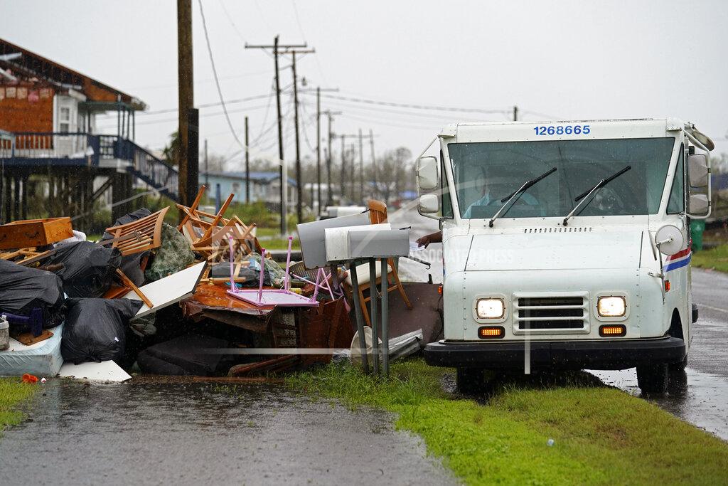 Gerald Herbert Derrick Campbell, postmaster for Montegut, La., delivers mail amidst destruction from Hurricane Ida, in Pointe-aux-Chenes, La., Tuesday, Sept. 14, 2021. (AP Photo/Gerald Herbert)