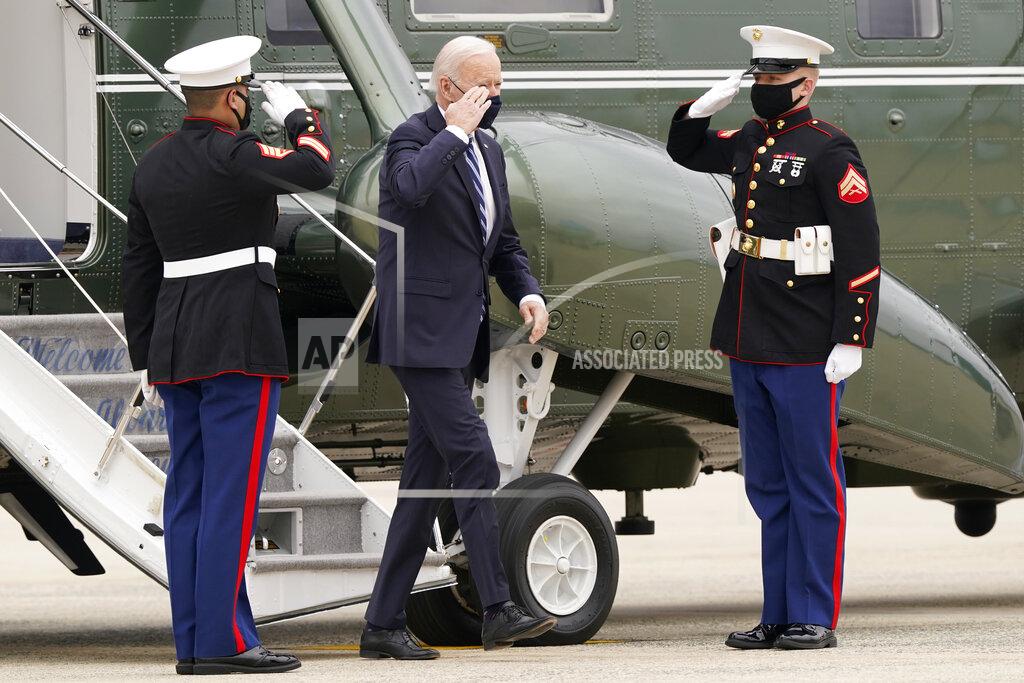 Susan Walsh President Joe Biden salutes as he walks off of Marine One and heads towards Air Force One at Andrews Air Force Base, Md., Tuesday, March 16, 2021, to depart for a trip to Pennsylvania. (AP Photo/Susan Walsh)