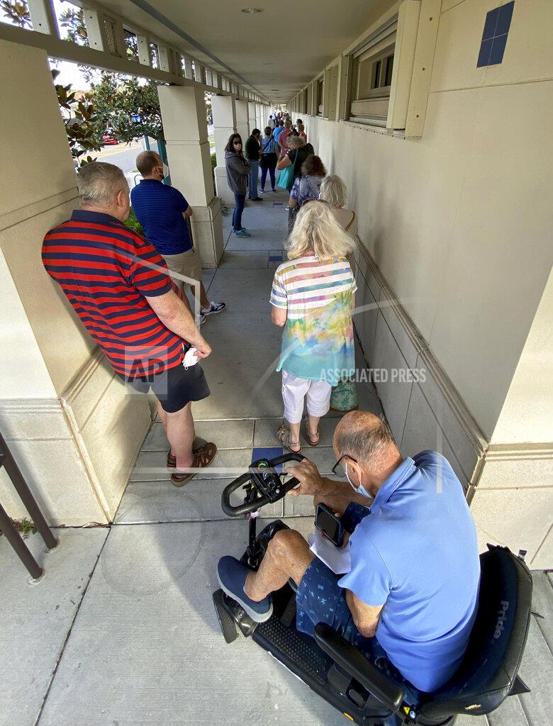 Tom Stathis People wait in a line in Sarasota, Fla., Thursday morning, Dec. 31, 2020, as COVID-19 vaccinations were made available to those over 65 and high-risk frontline health care workers. (Tom Stathis via AP)