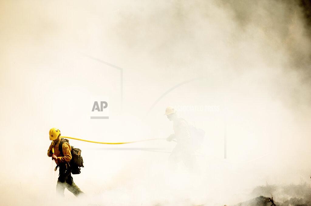 Noah Berger FILE - In this Sept. 19, 2021, file photo firefighters battling the Windy Fire extinguish a spot fire near the Trail of 100 Giants grove of Sequoia National Forest, Calif. California Gov. Gavin Newsom on Thursday, Sept. 23, 2021, approved nearly $1 billion in new spending to prevent wildfires, signaling a policy shift in a state that historically focused more on putting out fires than stopping them before they start. (AP Photo/Noah Berger, File)