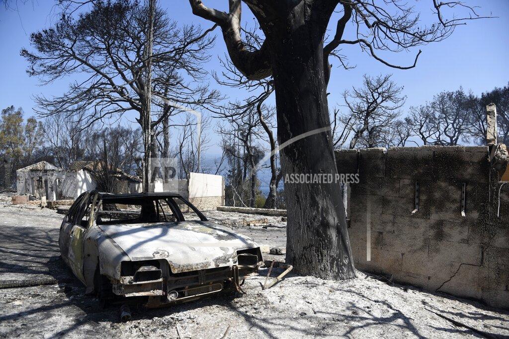 Andreas Alexopoulos Burned houses and a car after a wildfire in Lampiri village, east of Patras city, Greece, Sunday, Aug. 1, 2021. A wildfire that broke out Saturday in western Greece forced the evacuation of four villages and people on a beach by the Fire Service, the Coast Guard and private boats, authorities said. (AP Photo/Andreas Alexopoulos)