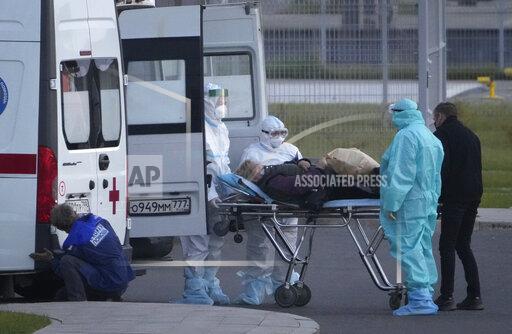 Medical workers carry a patient suspected of having coronavirus on a stretcher at a hospital in Kommunarka, outside Moscow, Russia, Monday, Oct. 11, 2021. Russia's daily coronavirus infections and deaths are hovering near all-time highs amid a laggard vaccination rate and the Kremlin's reluctance to toughen restrictions. Russia's state coronavirus task force reported 29,409 new confirmed cases Monday. That's the highest number since the start of the year and just slightly lower than the pandemic record reached in December. (AP Photo/Alexander Zemlianichenko)