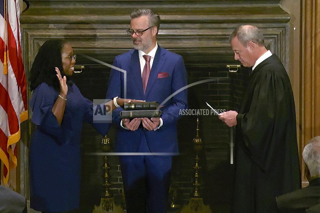 Uncredited In this image from video provided by the Supreme Court, Chief Justice of the United States John Roberts administers the Constitutional Oath to Ketanji Brown Jackson as her husband Patrick Jackson holds the Bible at the Supreme Court in Washington, Thursday, June 30, 2022. (Supreme Court via AP)