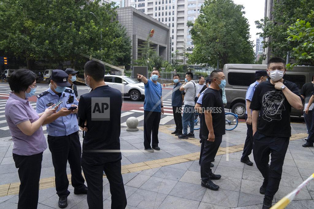 Mark Schiefelbein Plainclothes and uniformed police officers stand guard outside a courthouse in Beijing, Tuesday, Sept. 14, 2021. A young Chinese woman headed to court Tuesday amid a police cordon and antagonistic bystanders in one of the few remaining MeToo cases from a tamped-down movement whose legacy remains uncertain. (AP Photo/Mark Schiefelbein)