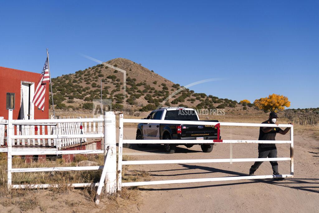 Jae C. Hong A security guard closes the gate after a Santa Fe County Sheriff's vehicle entered the Bonanza Creek Ranch in Santa Fe, N.M., Monday, Oct. 25, 2021. Production of the movie that Alec Baldwin was making when he shot and killed a cinematographer last week has been officially halted, but producers of the Western described the move as "a pause rather than an end." (AP Photo/Jae C. Hong)