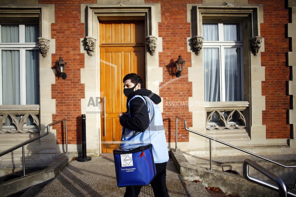Thibault Camus FILE - In this Jan. 18, 2021, file photo, medical delivery man Raphaël Abi Khalil arrives to deliver a box of Pfizer-BioNTech COVID-19 vaccines at a center in Saint-Denis, north of Paris. Many people lining up for vaccines in the Paris suburb are particularly grateful for the injections. The surrounding region is the poorest in mainland France, with 130 languages spoken and the country's highest rise in mortality last spring. (AP Photo/Thibault Camus, File)