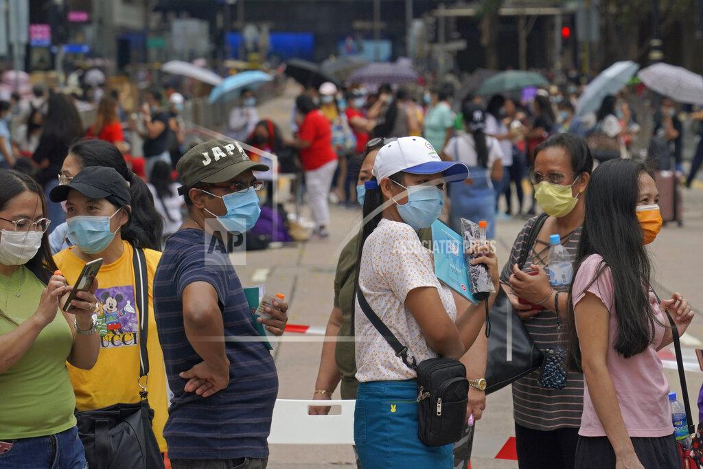 Kin Cheung In this Saturday, May 1, 2021, photo, domestic helpers from the Philippines line up at the temporary testing center for COVID-19, in Hong Kong. Hong Kong officials have dropped a plan to make it mandatory for foreign domestic workers to be vaccinated against the coronavirus, after the move drew criticism that it was discriminatory. (AP Photo/Kin Cheung)