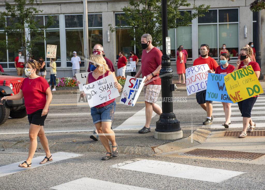 Andree Kehn Demonstrators cross Court street in Auburn as the group grew larger to line both sides of the street while maintaining social distancing on Wednesday, Aug. 12, 2020. The group was calling for a greater emphasis on safety in the return to school protocols. (Andree Kehn/Sun Journal via AP)