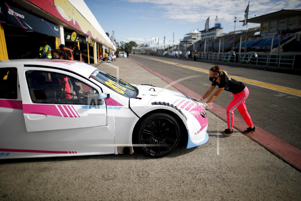 Natacha Pisarenko Vitarti Girl's Team mechanic Victoria Pascual pushes one of her team's racing cars into pits after a practice session at the Oscar y Juan Galvez track in Buenos Aires, Argentina, Friday, April 2, 2021. The Vitarti Girl's Team is the first all-female team in Argentina's motorsport history. (AP Photo/Natacha Pisarenko)