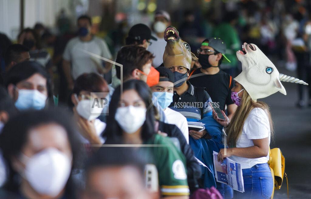 Eduardo Verdugo Young people, some wearing masks, wait to be vaccinated with a dose of the Pfizer COVID-19, during a vaccination drive for people between the ages of 18-29, in Mexico City, Thursday, Aug. 19, 2021. The capital’s south side borough of Xochimilco is encouraging young residents to dress up in costumes and compete for prizes if they come for their first COVID-19 vaccine dose. (AP Photo/Eduardo Verdugo)