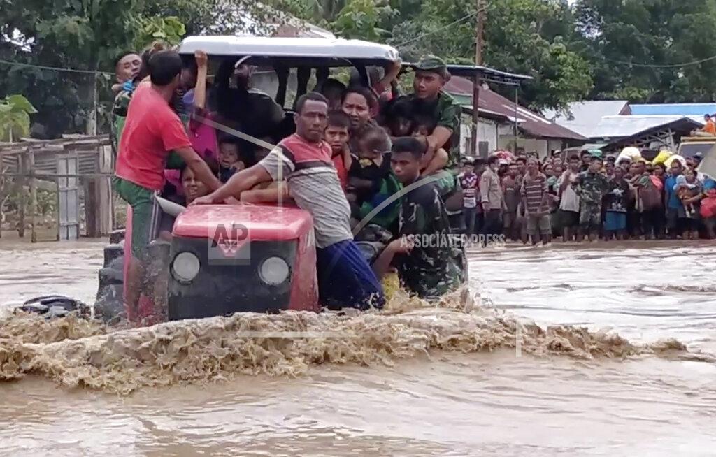 Uncredited In this image made from video, Indonesian soldiers use a tractor to help residents to cross a flooded road in Malaka Tengah, East Nusa Tenggara province, Indonesia, Monday, April 5, 2021. Multiple disasters caused by torrential rains in eastern Indonesia have left dozens of people dead and missing and displaced thousands, the country's disaster relief agency said Monday. (AP Photo)