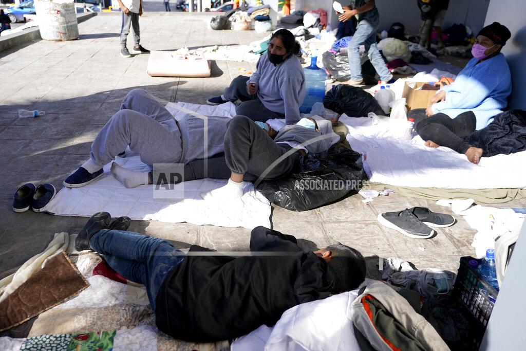 Julio Cortez Migrants who were caught trying to sneak into the United States and deported, eat near the McAllen-Hidalgo International Bridge point of entry into the U.S., Thursday, March 18, 2021, in Reynosa, Mexico. A surge of migrants on the Southwest border has the Biden administration on the defensive. The head of Homeland Security acknowledged the severity of the problem Tuesday but insisted it's under control and said he won't revive a Trump-era practice of immediately expelling teens and children. (AP Photo/Julio Cortez)
