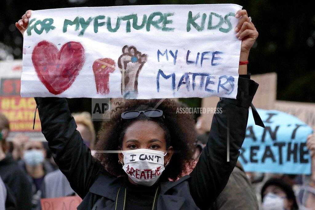 Rick Rycroft A woman holds a sign as protesters gather in Sydney, Tuesday, June 2, 2020, to support the cause of U.S. protests over the death of George Floyd and urged their own governments to address racism and police violence. Floyd died last week after he was pinned to the pavement by a white police officer who put his knee on the handcuffed black man's neck until he stopped breathing. (AP Photo/Rick Rycroft)