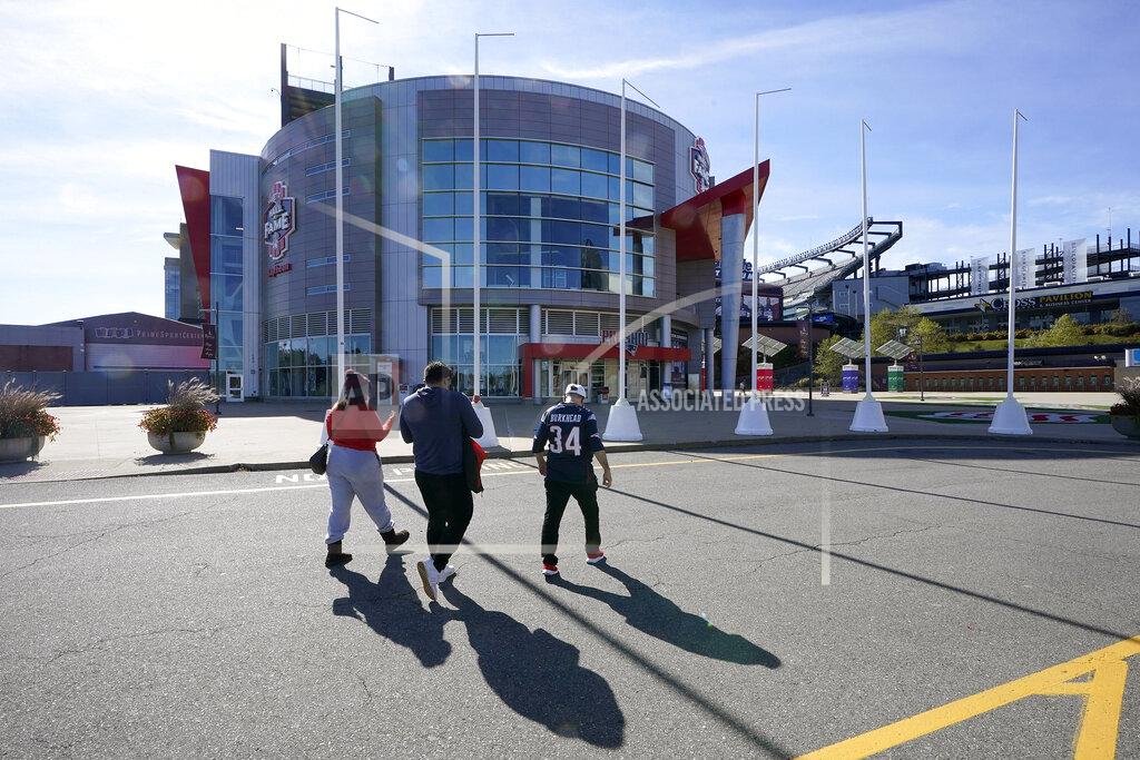 Steven Senne Football fans walk toward the Patriots ProShop at Gillette Stadium, Sunday, Oct. 11, 2020, in Foxborough, Mass. The NFL has postponed the Denver Broncos-New England Patriots football game due to another positive coronavirus test with the Patriots. (AP Photo/Steven Senne)