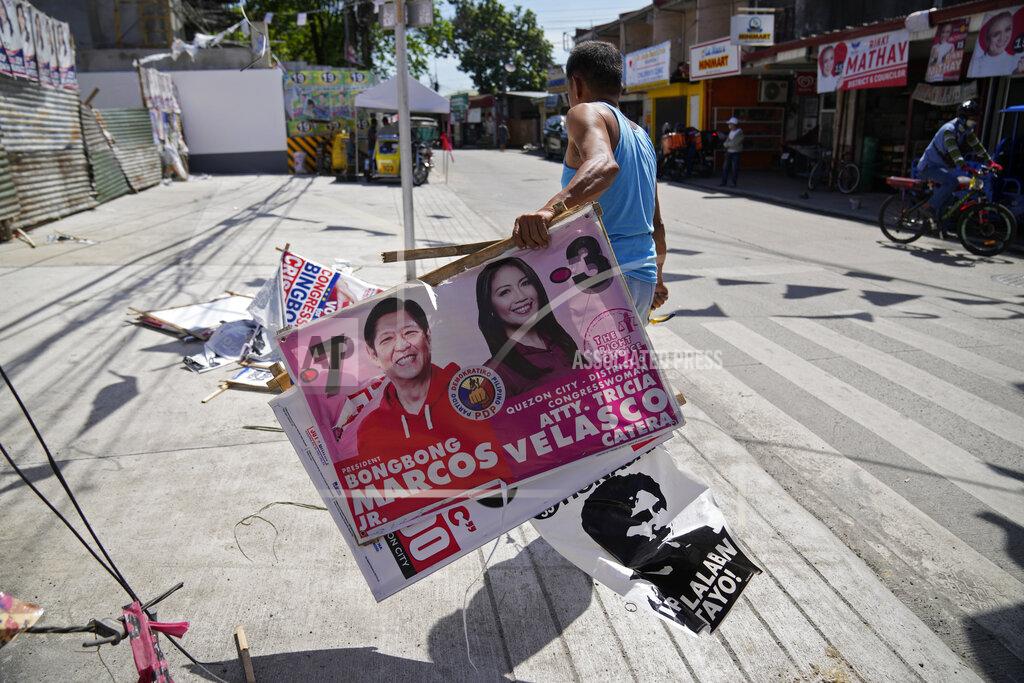Aaron Favila A village worker removes a campaign poster showing Presidential candidate Ferdinand "Bongbong" Marcos Jr., left, along a street in Quezon city, Philippines on Wednesday, May 11, 2022. Marcos, the namesake son of longtime dictator Ferdinand Marcos, apparent landslide victory in the Philippine presidential election is raising immediate concerns about a further erosion of democracy in Asia and could complicate American efforts to blunt growing Chinese influence and power in the Pacific. (AP Photo/Aaron Favila)