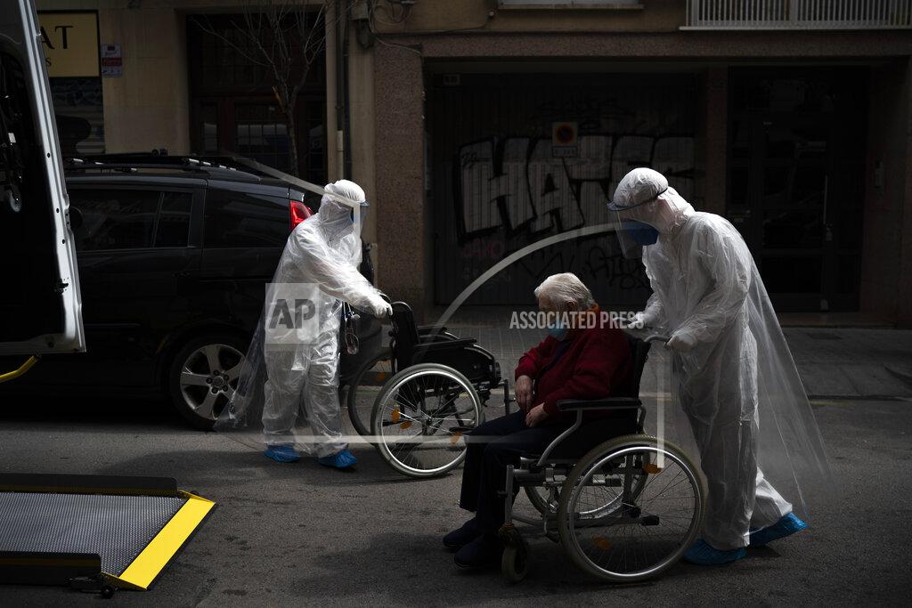 Felipe Dana A volunteer of the Spanish NGO Open Arms pushes in a wheelchair an elderly resident of a nursing home with coronavirus symptoms to a Hospital in Barcelona, Spain, April 11, 2020. (AP Photo/Felipe Dana)