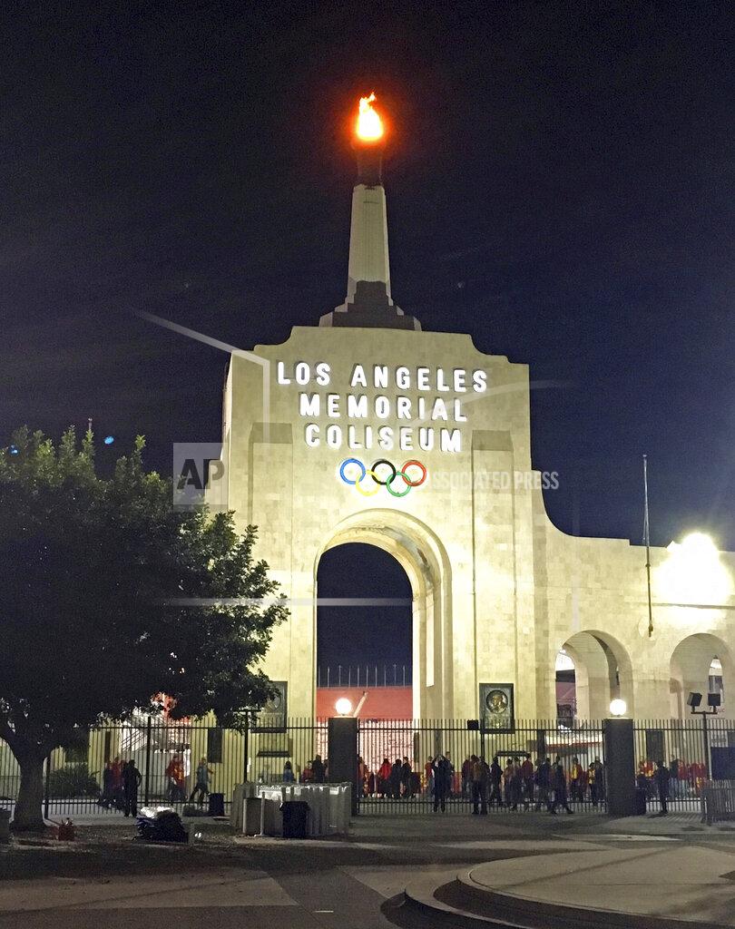 John Antczak This Nov. 4, 2017 photo, shows the peristyle of the Los Angeles Memorial Coliseum with the Olympic flame lit during a University of Southern California NCAA college football game in Los Angeles. United Airlines offered Friday, March 29, 2019, to withdraw from a $69 million deal to change Los Angeles Memorial Coliseum into United Airlines Memorial Coliseum following criticism that adding a corporate name is disrespectful to the facility's history of honoring troops who fought and died in World War I. (AP Photo/John Antczak)
