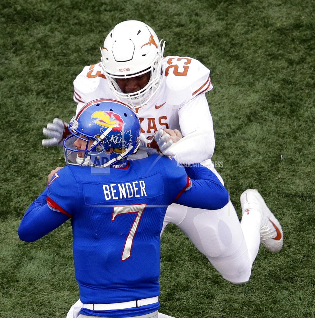 Orlin Wagner Texas linebacker Jeffrey McCulloch (23) forces a fumble by Kansas quarterback Peyton Bender (7) during the second half of an NCAA college football game in Lawrence, Kan., Friday, Nov. 23, 2018. Texas defeated Kansas 24-17. (AP Photo/Orlin Wagner)