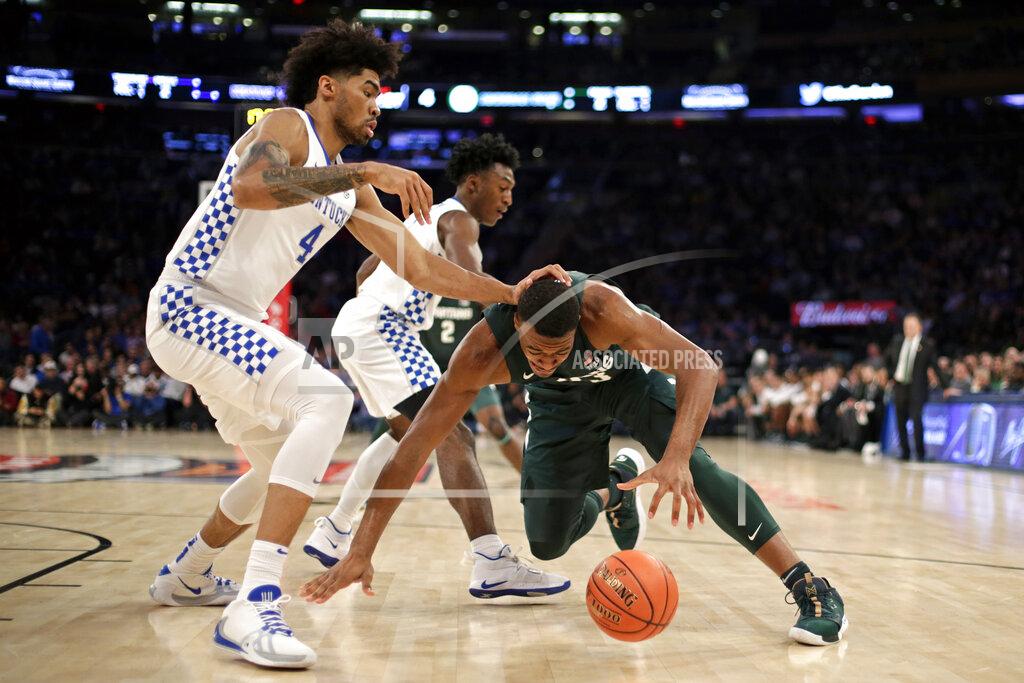 Adam Hunger Michigan State forward Xavier Tillman (23) falls to the court in front of Kentucky forward Nick Richards (4) during the first half of an NCAA college basketball game Tuesday, Nov. 5, 2019, in New York. (AP Photo/Adam Hunger)