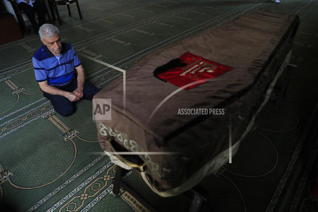 Hussein Malla The father of Ibrahim Harb, 35, a Lebanese man who was critically injured in the massive explosion at Beirut's port last year and who died on Monday nearly 14 months after the blast, prays at a mosque at his son's coffin in Beirut, Lebanon, Tuesday, Sept. 28, 2021. On Aug. 4, 2020, hundreds of tons of ammonium nitrate, a highly explosive material used in fertilizers, ignited after a massive fire at the port. The death brings to at least 215 the number of people who have been killed by the blast, according to official records. (AP Photo/Hussein Malla)