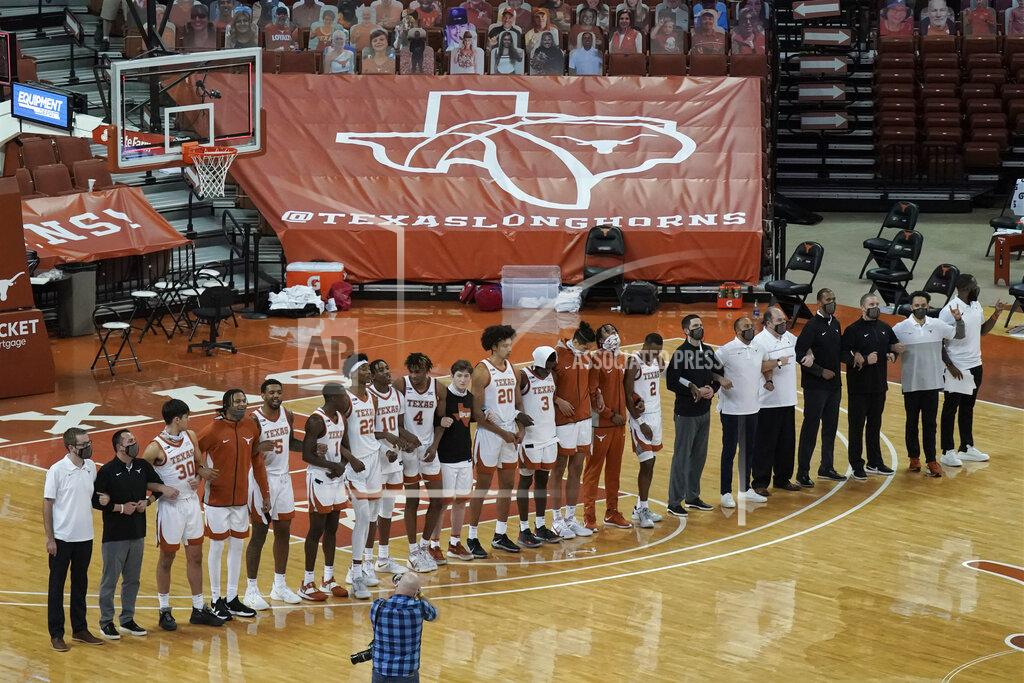 Chuck Burton FILE - In this Sunday, Dec. 20, 2020, file photo, Texas players sing "The Eyes Of Texas" after an NCAA college basketball game against Oklahoma State in Austin, Texas. The University of Texas' long-awaited report on the history of the school song “The Eyes of Texas” found it had “no racist intent,” but the school will not require athletes and band members to participate in singing or playing it at games and campus events. The song had erupted in controversy in 2020 after some members of the football team demanded the school stop playing it because of racist elements in the song’s past. (AP Photo/Chuck Burton, File)